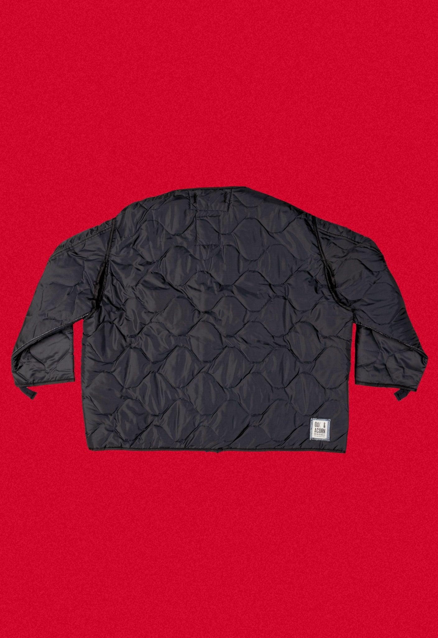 Black quilted repurposed denim jacket on a red background