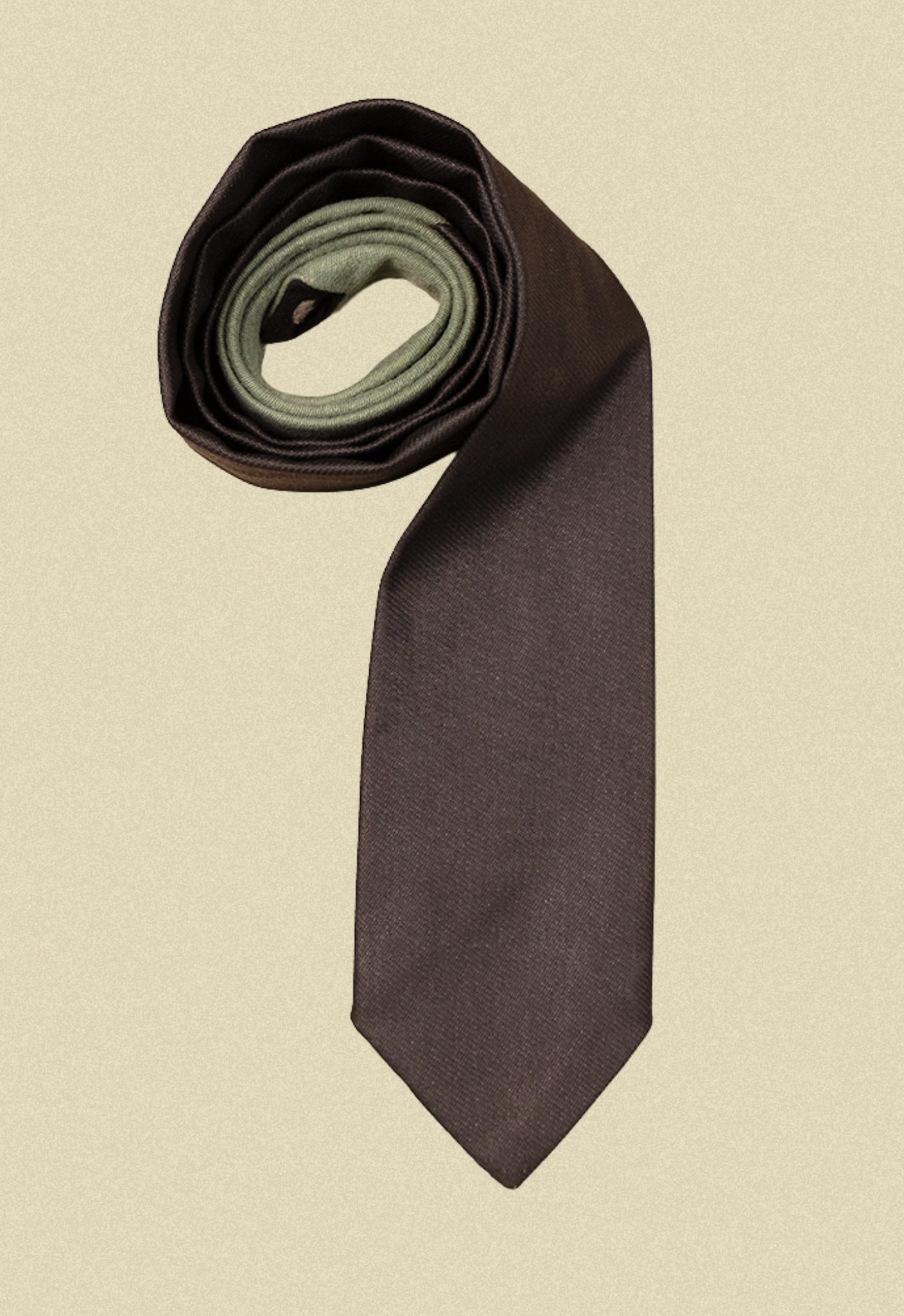 Repurposed coated black and army sateen tie on a beige background