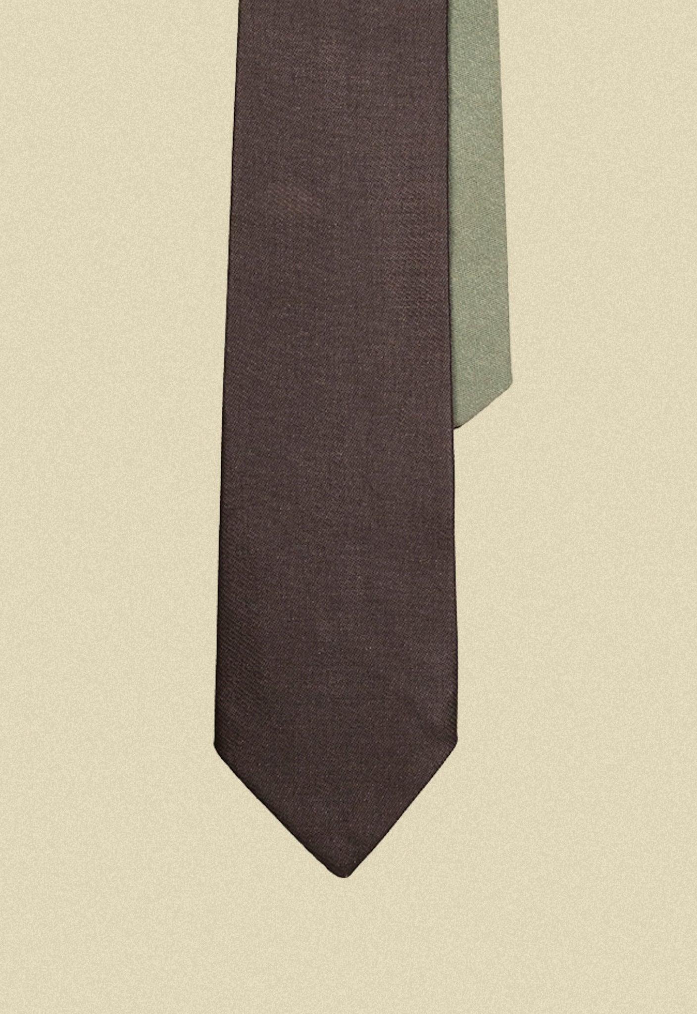 Repurposed coated black and army sateen tie on a beige background
